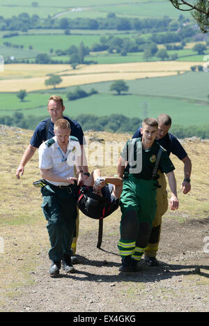 Shropshire Rettungsdienst und Shropshire Feuer und Rettung Offiziere tragen verletzte Frau zurück zum Krankenwagen Wrekin Hill Uk Stockfoto