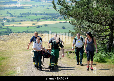 Shropshire Rettungsdienst und Shropshire Feuer und Rettung Offiziere tragen verletzte Frau zurück zum Krankenwagen Wrekin Hill Uk Stockfoto