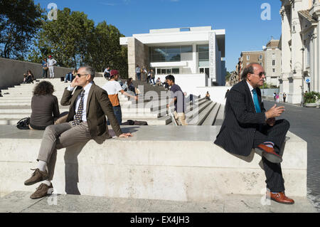 Italienische Männer Anzug sitzt durch die Ara Pacis Augustae auf Piazza Augusto Imperatore, Rom, Italien Stockfoto