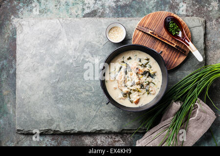 Cremige Suppe mit Aal in schwarz Eisentopf auf Stein Schiefer-Hintergrund Stockfoto