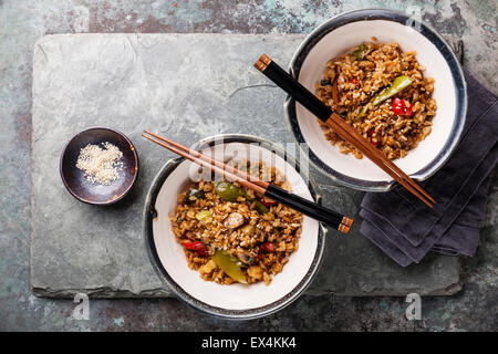 Gebratener Reis mit Gemüse und Sesam auf Stein Schiefer Hintergrund Stockfoto
