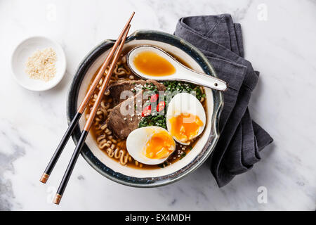 Asiatische Miso Ramen-Nudeln mit Rindfleisch und Ei in Schüssel auf weißem Marmor Hintergrund Stockfoto