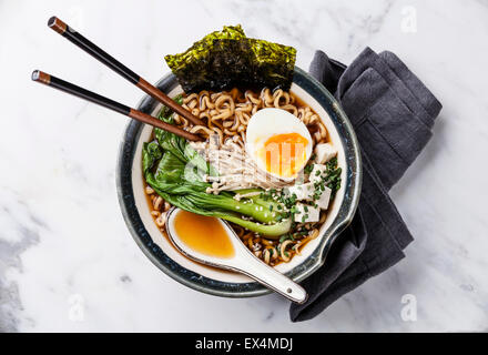 Miso Ramen asiatische Nudeln mit Ei, Enoki und Pak Choi Kohl in Schüssel auf weißem Marmor Hintergrund Stockfoto