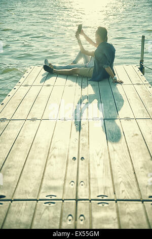 Paar in der Liebe, die sitzen auf dem Pier, selfie Stockfoto