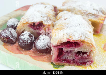 Hausgemachte frische Kirschkuchen mit Zucker überzogen und verziert mit rohen Kirschen auf dem Silbertablett serviert Stockfoto