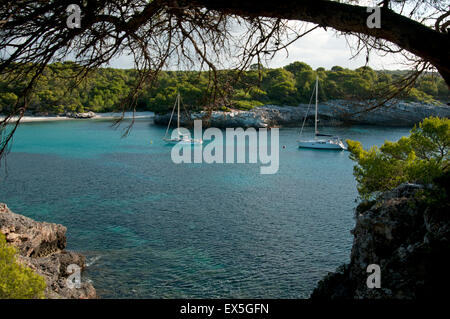 Zwei Segelyachten vor Anker in den ruhigen türkisfarbenen Gewässern bei Cala Turqueta auf der Insel Menorca Spanien Stockfoto