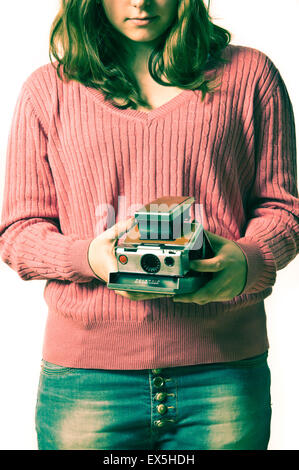 schen Mädchen hält eine Kamera Polaroid SX70 Stockfoto