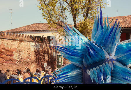 Kunden, die Restaurants und Bars im Freien neben einem riesigen blauen Glas Skulptur Campo Santo Stefano Murano venezianischen Lagune Veneto Italien Europa Stockfoto