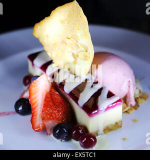Blaubeer-Käsekuchen serviert mit Heidelbeeren, Erdbeeren, eine Waffel und Eis im Restaurant Las Palmas in Rotterdam. Stockfoto