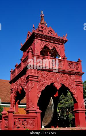 Lamphun, Thailand: Dekorative rote Trommel- und Glockenturm mit kreisförmigen Gong Drum hing in den offenen Bögen auf Thai Tempel Stockfoto