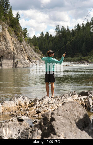 Junge Fliegenfischer Gießen seinen Stab in einen Fluss Montana Stockfoto