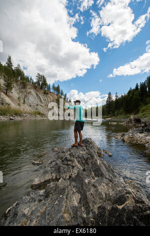 Junge Fliegenfischer Gießen seinen Stab in einen Fluss Montana Stockfoto