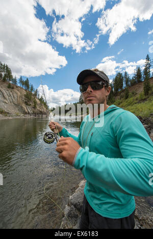 Junge Fliegenfischer Gießen seinen Stab in einen Fluss Montana Stockfoto