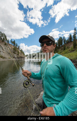 Junge Fliegenfischer Gießen seinen Stab in einen Fluss Montana Stockfoto