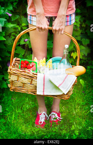 Junges Mädchen mit einem Picknick-Korb mit Beeren, Limonade und Brot. Stockfoto