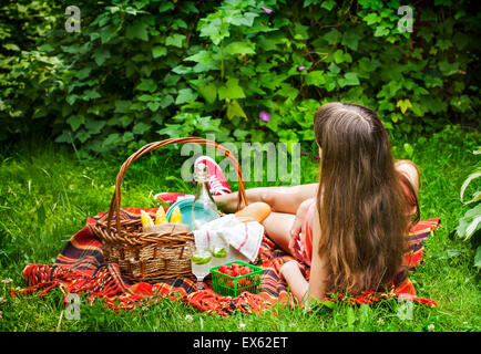 Junges Mädchen auf ein Picknick mit einem Korb voller Lebensmittel Stockfoto