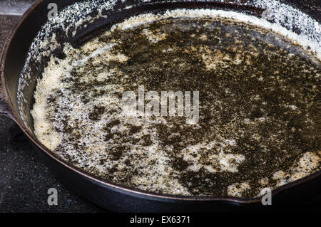 Zerlassener Butter im heißen gusseisernen Pfanne Stockfoto