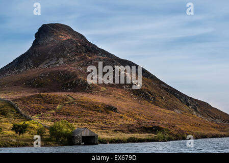 Landschaft mit steilen Hügel mit kleinen Bootshaus am See im Vordergrund Stockfoto