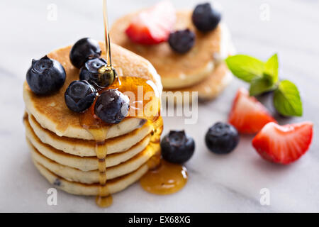 Stapel von kleinen Pfannkuchen mit Beeren auf Marmor Stockfoto