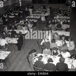 1950er-Jahren, historische, Overhead Blick auf eine Personal oder Werke Kantine, zeigt Arbeiter beim Mittagessen. Stockfoto