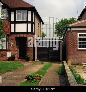 Viktorianische Gasometer hinter London Vorortsheimen. 2003 Stockfoto