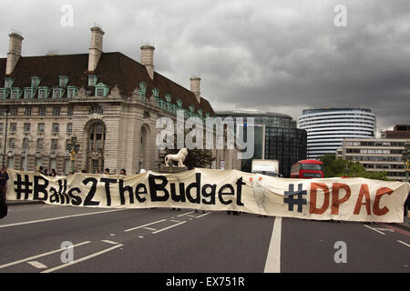 London, UK. 8. Juli 2015. Pressure Group "behinderte Menschen gegen die Kürzungen" stoppen Verkehr auf Westminster Bridge mit einem riesigen Banner, als Demonstranten gegen Kanzler George Osbourne Haushalt kommen zusammen in eine Demonstration, dass sie "Balls zum Haushalt" nennen. Gegen Sparpolitik und Behinderung Aktivisten aus Protest gegen was sie sehen, wie ein Haushalt, der verfolgt und verteufelt Leistungsempfänger, dann marschierte vorbei an Parlament und blockiert Westminster Bridge Credit mehrfarbige Kugeln in Whitehall vor Downing Street freigesetzt: Patricia Phillips/Alamy Live News Stockfoto