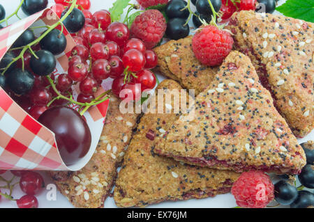 Integrale Kekse mit frischen Johannisbeeren Kirschen und Himbeeren auf dem Tisch gestapelt Stockfoto