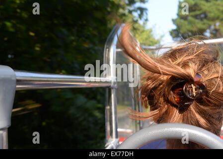 Frau mit im Wind wehenden Haaren auf einem offenen Oberteil Bustour Stockfoto