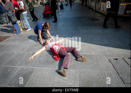 Exeter, Devon, UK. 8. Juli 2015. Der Umriss einer Frau wird auf den Bürgersteig gezeichnet, während der Exeter Budget Tag Aktion #AusterityKills in Exeter City Centre am 8. Juli 2015 in Bedford Square, Exeter, UK Credit: Clive Chilvers/Alamy Live News Stockfoto