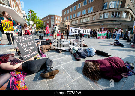 Exeter, Devon, UK. 8. Juli 2015. Demonstranten gegen Sparpolitik spielen tot während der Exeter Budget Aktionstag #AusterityKills in Exeter City Centre am 8. Juli 2015 in Bedford Square, Exeter, UK Credit: Clive Chilvers/Alamy Live News Stockfoto