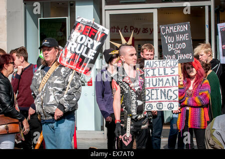 Exeter, Devon, UK. 8. Juli 2015. Demonstranten halten Plakate Denoncing Sparmaßnahmen bei der Exeter Budget Aktionstag #AusterityKills in Exeter City Centre am 8. Juli 2015 in Bedford Square, Exeter, UK Credit: Clive Chilvers/Alamy Live News Stockfoto