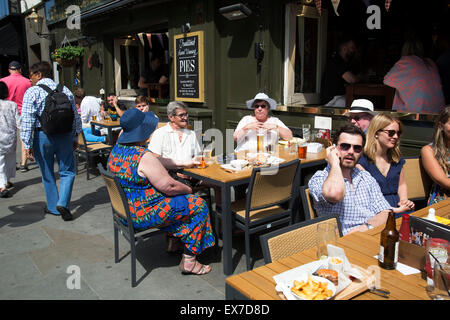 Sommer in London, England, Vereinigtes Königreich. Menschen trinken vor einem Pub auf einer belebten Ecke im Covent Garden. Dies ist einer der belebtesten Gegenden im West End. Stockfoto