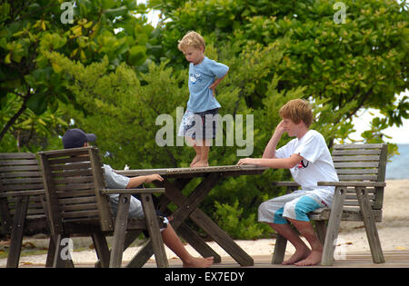 Kleiner Junge tanzt auf den Holztisch, Denis Island, Seychellen Stockfoto