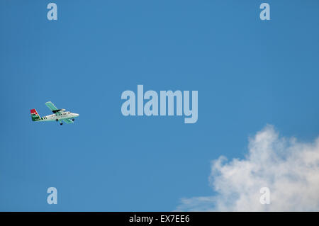 Ein kleines Passagierflugzeug fliegt über eine Wolke, Denis Island, Seychellen Stockfoto