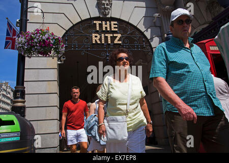 Sommer in London, England, Vereinigtes Königreich. Über die gewölbte Brücke passieren Touristen zum berühmten Ritz Hotel auf Piccadilly, Mayfair. Ritz, London ist ein Denkmalgeschütztes 5-Sterne Hotel in Piccadilly in London, England. Ein Symbol der High-Society und Luxus, das Hotel ist eines der renommiertesten und bekanntesten Hotels der Welt. Stockfoto