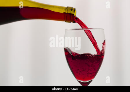 Rotwein in Weinglas gießen Stockfoto