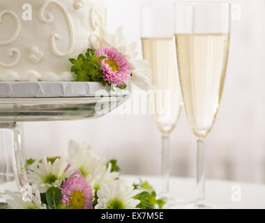 Hochzeitstorte und Champagner-Flöten Stockfoto