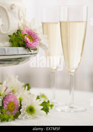 Hochzeitstorte und Champagner-Flöten Stockfoto