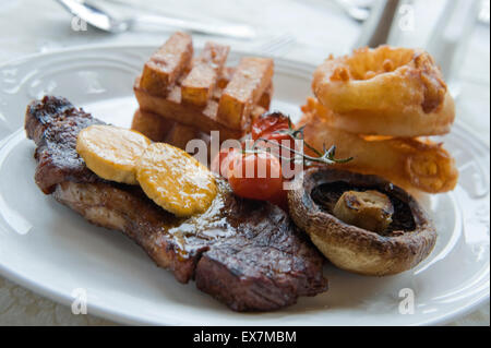 Steak und Chips auf einem weißen Teller. Stockfoto