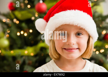 Lächeln auf den Lippen tragen Weihnachtsmütze Mädchen (6-7) Stockfoto