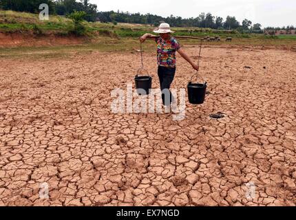 Chuxiong, chinesischen Provinz Yunnan. 8. Juli 2015. Ein Bauer führt das Wasser auf einem ausgetrockneten Feld in Xinqiao Gemeinde, Yi autonomen Präfektur Chuxiong, Südwesten der chinesischen Provinz Yunnan, 8. Juli 2015. Die anhaltende Dürre in Chuxiong betroffen waren fast 210.000 Menschen und 53.360 Hektar Ackerland. Bildnachweis: Yang Zongyou/Xinhua/Alamy Live-Nachrichten Stockfoto