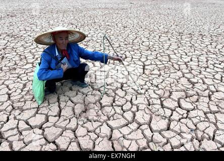 Chuxiong, chinesischen Provinz Yunnan. 8. Juli 2015. Bauer Li Zailiang befasst sich mit einem ausgetrockneten Teich in Mouding County, Yi autonomen Präfektur Chuxiong, Südwesten der chinesischen Provinz Yunnan, 8. Juli 2015. Die anhaltende Dürre in Chuxiong betroffen waren fast 210.000 Menschen und 53.360 Hektar Ackerland. Bildnachweis: Yang Zongyou/Xinhua/Alamy Live-Nachrichten Stockfoto