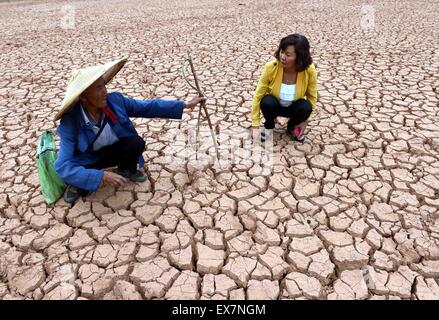 Chuxiong, chinesischen Provinz Yunnan. 8. Juli 2015. Bauer Li Zailiang (L) spricht über Trockenheit mit einem Mitarbeiter von lokalen Dürre Relief-Abteilung auf einem ausgetrockneten Teich in Mouding County, Yi autonomen Präfektur Chuxiong, Südwesten der chinesischen Provinz Yunnan, 8. Juli 2015. Die anhaltende Dürre in Chuxiong betroffen waren fast 210.000 Menschen und 53.360 Hektar Ackerland. Bildnachweis: Yang Zongyou/Xinhua/Alamy Live-Nachrichten Stockfoto