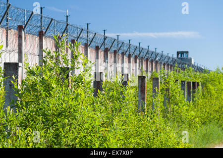 Unscharfen Hintergrund der Gefängnismauer und scharfen Draht Widerhaken aufgerollt Stockfoto