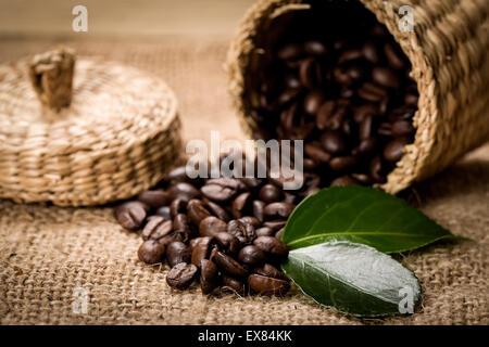 Haufen von Kaffeebohnen und Holzlöffel in Glas Stockfoto