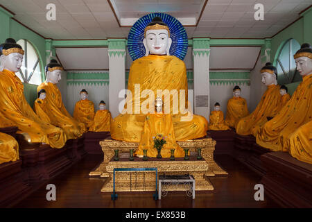Buddha-Statuen mit gelben Roben, Shwedagon-Pagode, Yangon, Myanmar Stockfoto