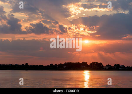 Sommer Sonnenaufgang mit schönen bewölkten Himmel über ruhige See Wasser Stockfoto