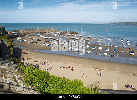 Der Hafen und die Sonnenanbeter am Strand von New Quay, Ceredigion, Wales gesehen von der Stadt an einem sonnigen Sommertag Stockfoto