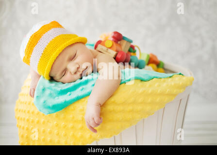 Niedliche Baby schläft im Weidenkorb Stockfoto