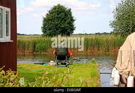 Ein Angler Angeln Fluss Thurne auf den Norfolk Broads in Martham, Norfolk, England, Vereinigtes Königreich. Stockfoto